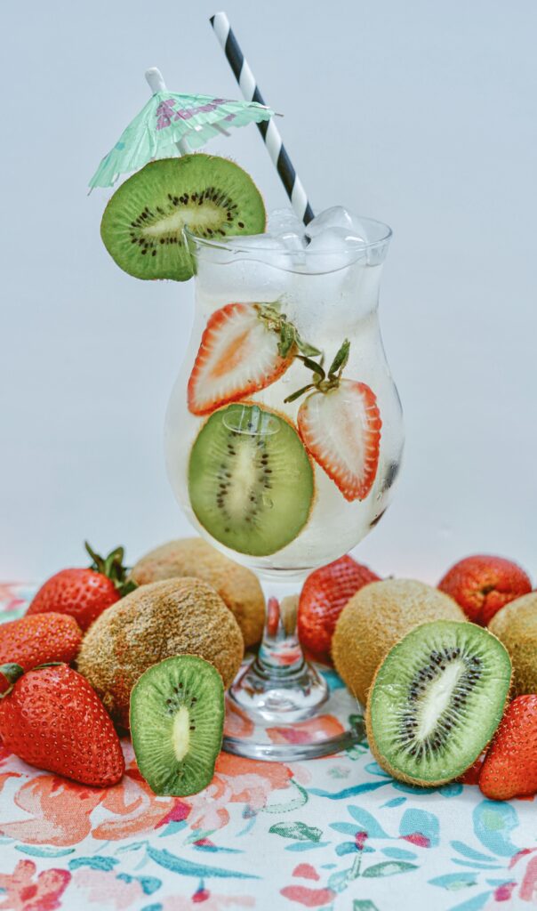 Fill a glass with ice cubes, kiwi slices & strawberries.